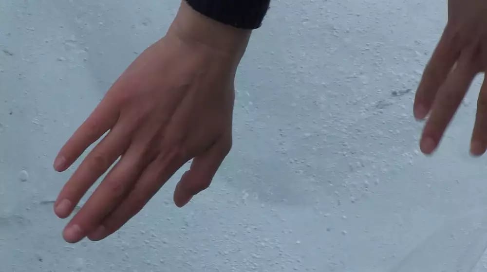 A pair of hands melting a large piece of ice