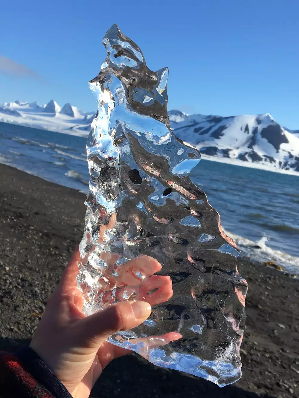 A piece of ice that has been sculpted by warm hands melting it. Set in the arctic