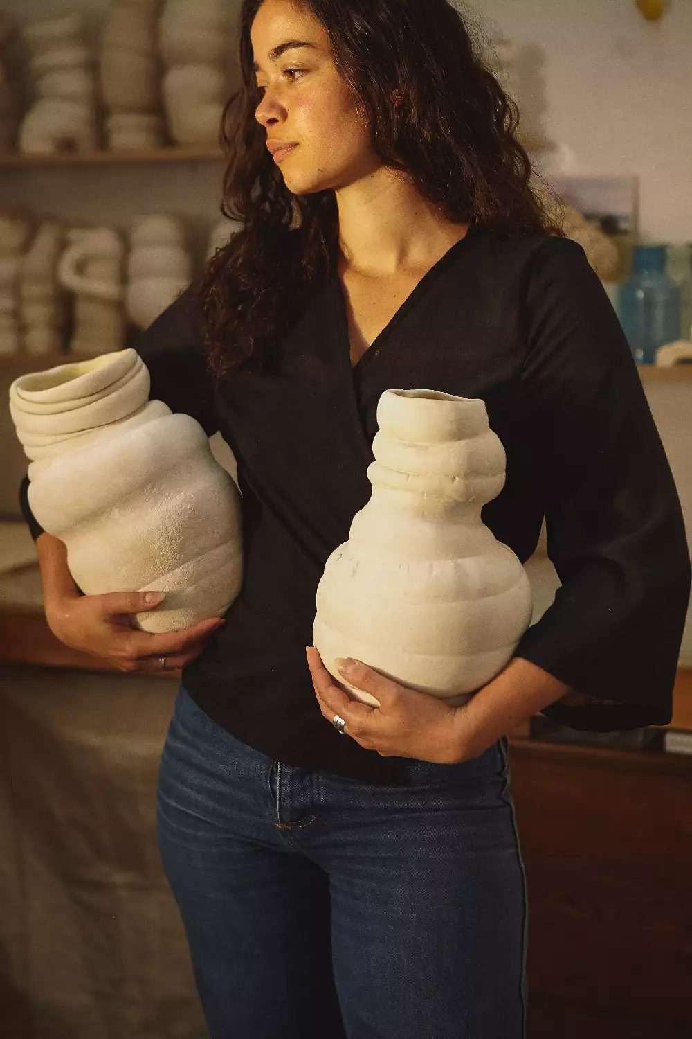 Portrait by Sarah Victoria Bates Image shows the artist holding two of the sculptures