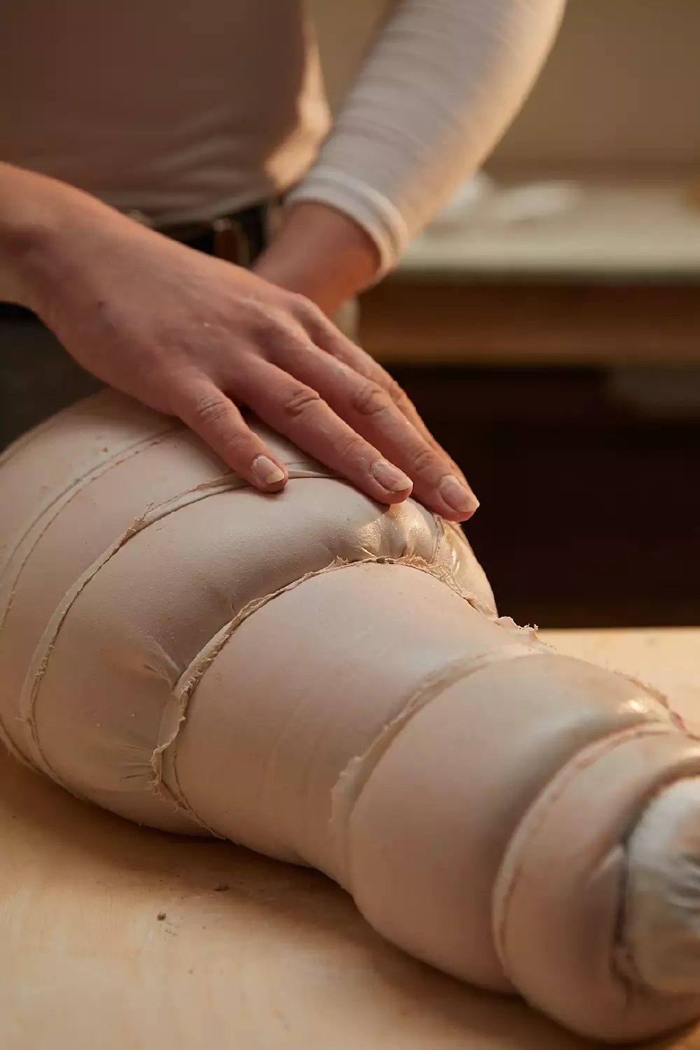 Photograph by Sarah Victoria Bates Image shows a close up of the artists hands working on a sculpture